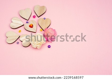 Pink background for the holidays Valentine's Day, Tu B'Av, Qixi Festival. Dried flower buds and Wooden hearts Royalty-Free Stock Photo #2239168597