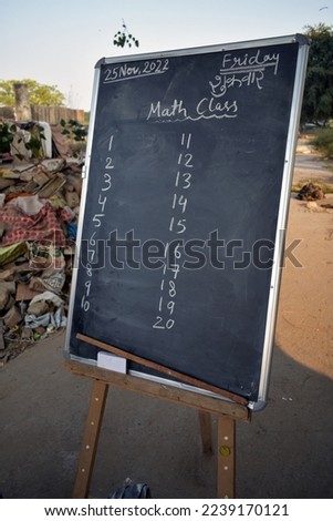 Mathematics class on blackboard at roadside. Open school concept for poor children.