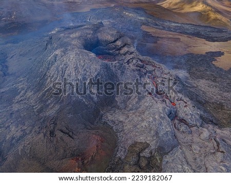 active volcano on Reykjanes peninsula by day. Volcanic crater in Iceland. Dark magma rock around the crater. small lava flows in the crater before the eruption. Little smoke near the crater