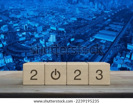 2023 start up business icon on wood block cubes on wooden table over modern city tower, street, expressway and skyscraper, Happy new year 2023 success concept