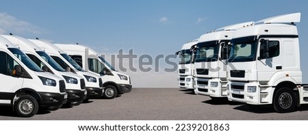 Semi trucks and delivery vans are parked in rows. Commercial fleet Royalty-Free Stock Photo #2239201863