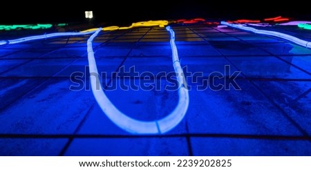 Illuminated letters and words made with neon lights and blue LEDs of many colors and red and totally black background. Jazz poster aesthetic. Wires and tubes linked to create shapes.