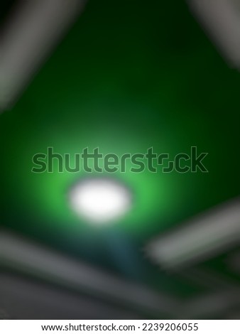 Defocused or blurred abstract background of a green ceiling and its white lines of a room