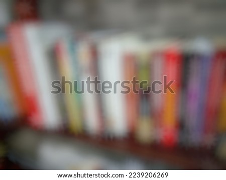 Defocused or blurred abstract background of colorful books in a wooden shelf
