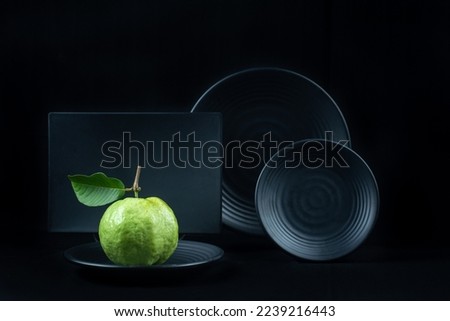 still life with fruit on black background round plate and square plate