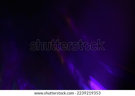 Blur neon light. Lens flare overlay. Bokeh fluorescent flash gleam. Defocused blue purple color flecks on dark black abstract background. Royalty-Free Stock Photo #2239219353