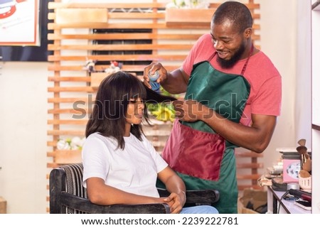 young african lady in a hair salon to get her hair done Royalty-Free Stock Photo #2239222781