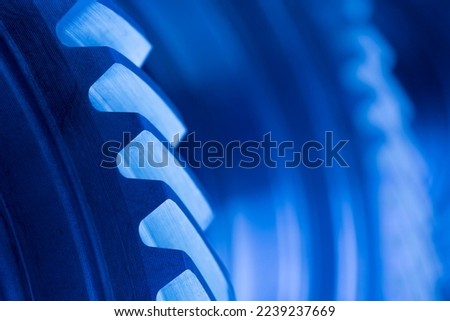 Close-up of cog wheels in an engine or machine in blue color Royalty-Free Stock Photo #2239237669