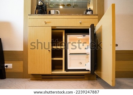 a refrigerator under the bar counter, according to the appearance of the refrigerator, it is a small size that is found only at the hotel, and can only hold a limited amount of stuff. Royalty-Free Stock Photo #2239247887