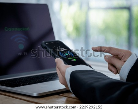 personal hotspot technology concept. The words personal hotspot, internet sharing icon and green activated button on mobile smart phone screen in hand, connecting wi-fi network to laptop computer. Royalty-Free Stock Photo #2239292155