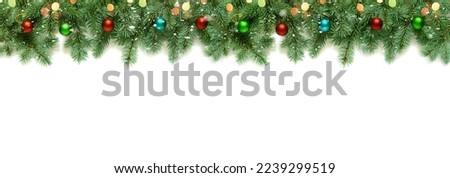 New Year's decor from branches of a Christmas tree and New Year's toys with lights of light bulbs, snow and bokeh isolated on a white background, copy space Royalty-Free Stock Photo #2239299519