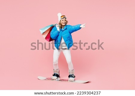 Snowboarder woman wear blue suit goggles mask hat ski jacket hold package bags after shopping isolated on plain pink background Winter extreme sport hobby trip relax, Black Friday sale buy day concept