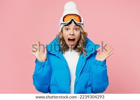 Snowboarder surprised woman wear blue suit goggles mask hat ski padded jacket spend extreme weekend spread hands say wow isolated on plain pastel pink background. Winter sport hobby trip relax concept