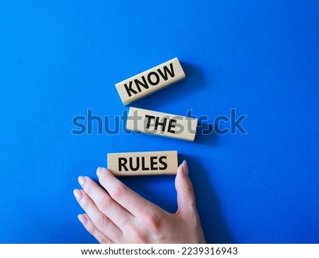 Know the rules symbol. Wooden blocks with words Know the rules. Beautiful blue background. Businessman hand. Business and Know the rules concept. Copy space.