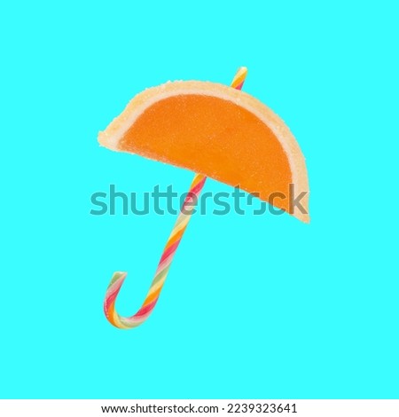 Sweet umbrella shaped jelly slice and candy cane sugar isolated on turquoise blue background. Creative parasol food concept idea Royalty-Free Stock Photo #2239323641