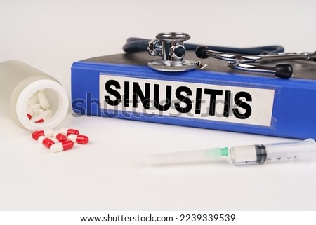 Medical concept. On a white surface there are pills, a syringe, a stethoscope and a folder with the inscription - Sinusitis