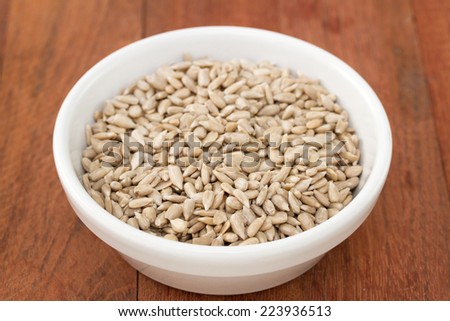 sunflower seeds in white bowl on dark background