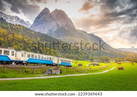 Train in Bavarian alps at autumn and wooden barns at sunset, Garmisch, Germany Royalty-Free Stock Photo #2239369643