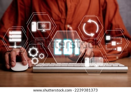 EDI-electronic data interchange concept, Person using computer on office desk with virtual screen EDI icon.