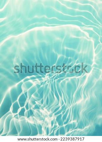 Closeup​ blur​ abstract​ of​ surface​ blue​ water​ for​ background. Reflection​ on​ surface​ blue​ water​ in​ the​ sea. Reflection​ of​ sunlight​ with​ surface​ blue​ water​ in​ the​ swimming​ pool.