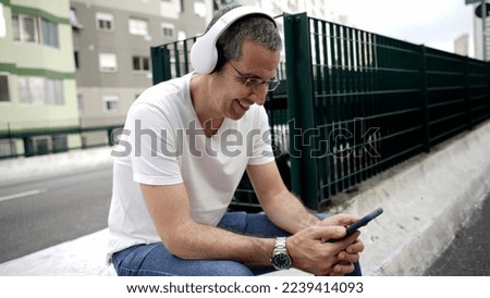 man relaxes and listens to music resting in a park