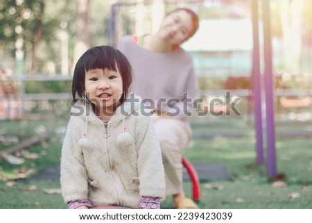 The girl playing with mother at park.