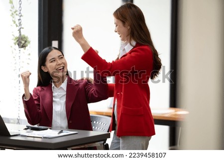 Excited concept, Happy young woman high fiving with colleague in office.