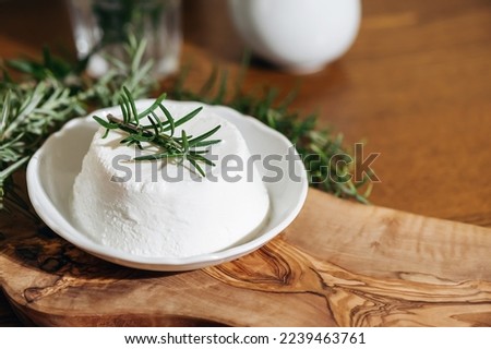 Piece of Ricotta cheese. Top italian cheeses - Ricotta Cheese. Ricotta cheese or cottage cheese with rosemary on white plate. Royalty-Free Stock Photo #2239463761