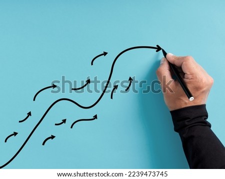 Leadership and following the leader. Guidance and leading the way in business. Hand draws a curved arrow line with many small follower lines. Royalty-Free Stock Photo #2239473745