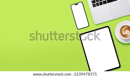 Laptop, tablet and smartphone with blank screen on green background. Flat lay with copy space