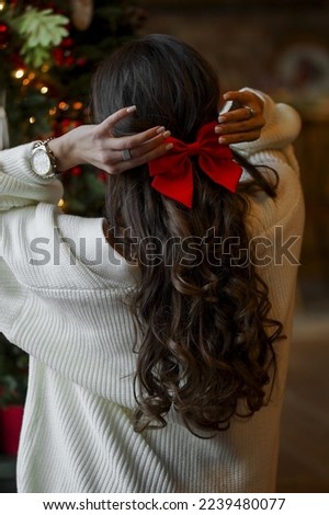 Woman near Christmas tree is waiting new year 2023