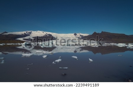 Ice floating in northern sea landscape photo. Beautiful nature scenery photography with snowy mountain on background. Idyllic scene. High quality picture for wallpaper, travel blog, magazine, article
