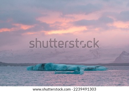 Glaciers floating near mountains landscape photo. Beautiful nature scenery photography with sunset sky on background. Idyllic scene. High quality picture for wallpaper, travel blog, magazine, article