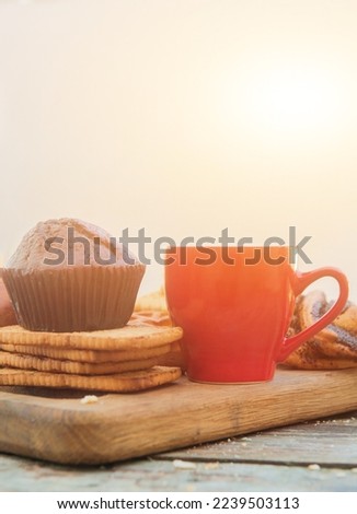 Empty space red coffee cup template with chocolate muffin in outdoor city cafe, sunny morning breakfast