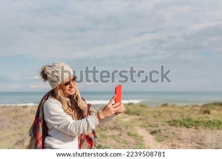 traveler woman taking a selfie on the beach with mobile phone Royalty-Free Stock Photo #2239508781