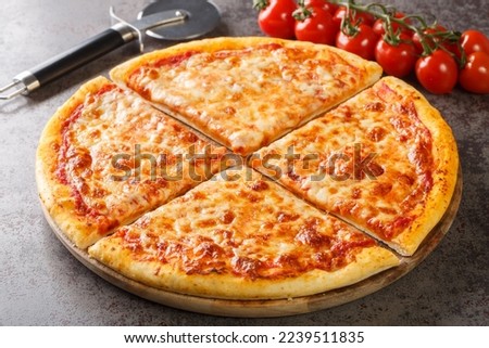 Homemade New York style pizza with mozzarella cheese and spicy tomato sauce close-up on a wooden board on the table. Horizontal
