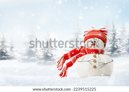 happy snowman in a snowdrift, in a red hat and scarf against the backdrop of a winter forest