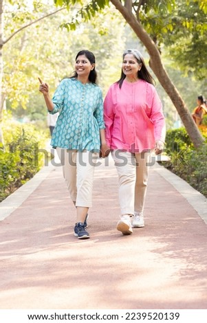 Happy mother and daughter admiring view at park Royalty-Free Stock Photo #2239520139