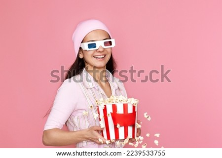 woman holding bucket of popcorn and jumping