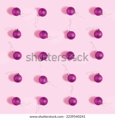 Purple baubles on pastel pink background. Minimal square flat lay composition, seamless pattern, Christmas and New Year celebration concept