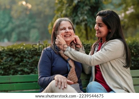 Two indian woman sitting in winter wear and enjoying at park