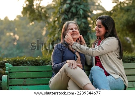 Two indian woman sitting in winter wear and enjoying at park