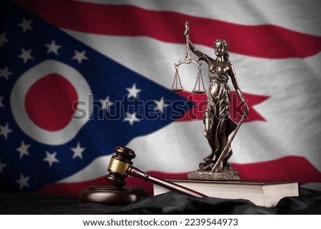 Ohio US state flag with statue of lady justice, constitution and judge hammer on black drapery. Concept of judgement and punishment Royalty-Free Stock Photo #2239544973