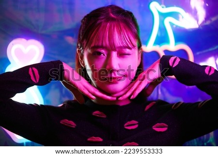 Portrait of a young Asian woman with neon sign