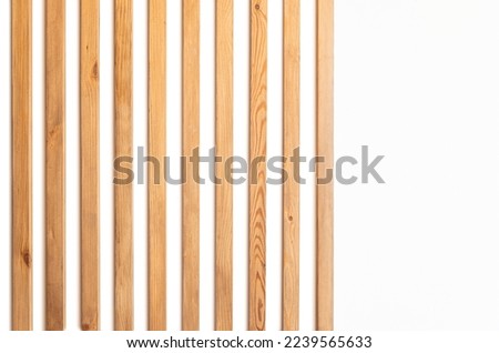 narrow wooden slats on a white plastered wall as an element of modern decor in a minimalistic interior design Royalty-Free Stock Photo #2239565633