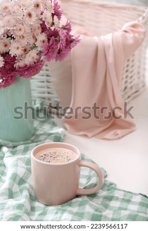 Cup of fresh coffee and beautiful bouquet on white table