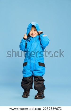 Portrait of little boy, child posing in astronaut costume over blue studio background. Developer. Concept of childhood, emotions, lifestyle, fashion, happiness. Copy space for ad