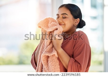 Woman smelling clean laundry, blanket or fabric for fresh and clean smell in house after doing washing, cleaning and housekeeping. Happy female cleaner with textile for aroma, fragrance and scent Royalty-Free Stock Photo #2239596185