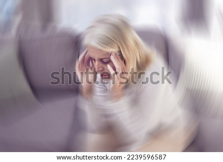 Senior woman, headache and sofa in home with motion blur, pain and depressed while tired in retirement. Elderly, old woman and anxiety with burnout, depression and panic attack on couch at house Royalty-Free Stock Photo #2239596587