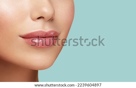 Close-up photo of women's lips. Cosmetology beauty injection procedure. Hyaluronic acid. Lip protection balm. Hygienic lipstick Royalty-Free Stock Photo #2239604897